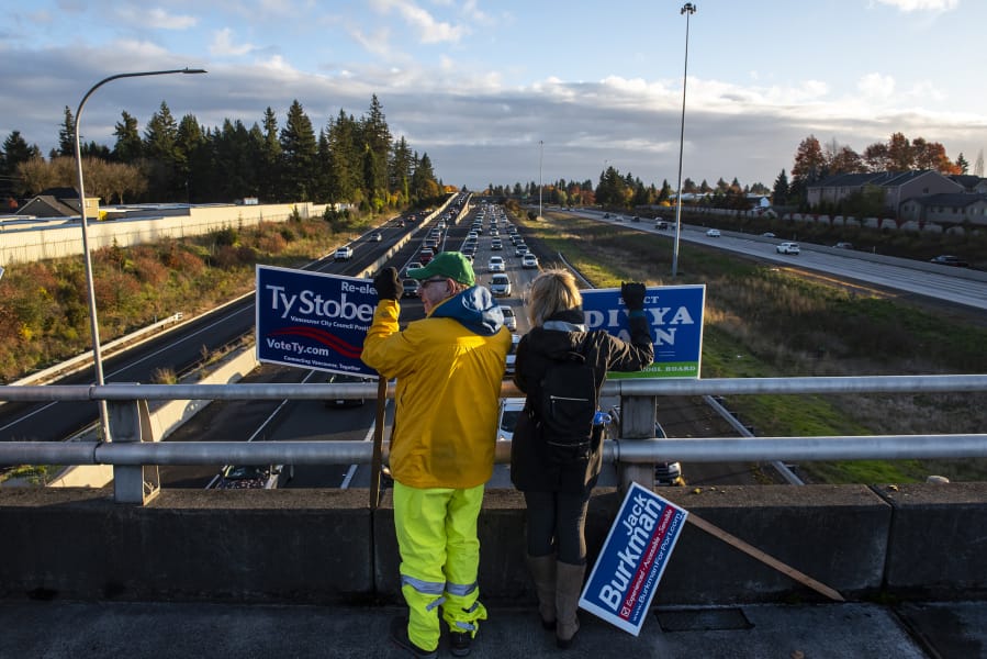 Lehman Holder, left, and Sharon Fujioka, both with the Sierra Club, campaign for various Vancouver candidates Friday on the Interstate 205 overpass on Northeast Ninth Street in Vancouver.