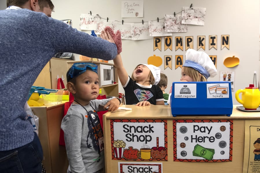 Thomas Duncan encourages his students, from left, Austin Park, 3,  Addison Horn, 3, and Rylie Allen, 3, to keep playing while a tour observes the class in district's new the Early Learning Center. To keep up with rapid growth, the school board plans to ask voters to approve a facilities bond next February.