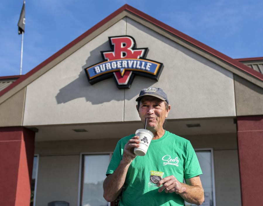 Clatskanie, Ore., mint farmer Mike Seely sips on a mint patty milkshake outside of the Burgerville in Kelso Monday. Burgerville, a Pacific Northwest fast-food chain, recently added Seely&#039;s signature mint patty flavor to its list of locally sourced milkshakes.