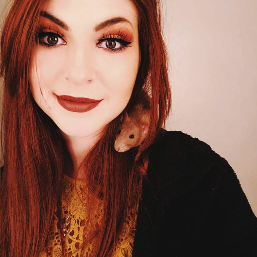 Abby Chronister carries Mist, a Russian cinnamon fancy rat, on her shoulder during a selfie.