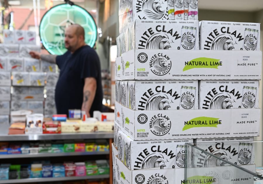 Cartons of White Claw, a flavored alcoholic fizz in a can, are on display at the Round The Clock Deli in New York City. (Timothy A.