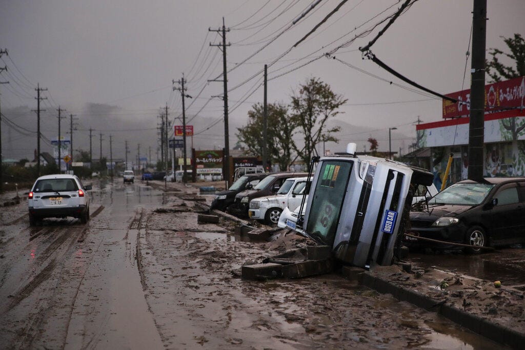 Typhoon-damaged cars sit on the street covered with mud Monday, Oct. 14, 2019, in Hoyasu, Japan. Rescue crews in Japan dug through mudslides and searched near swollen rivers Monday as they looked for those missing from typhoon Hagibis that left as many as 36 dead and caused serious damage in central and northern Japan. (AP Photo/Jae C.
