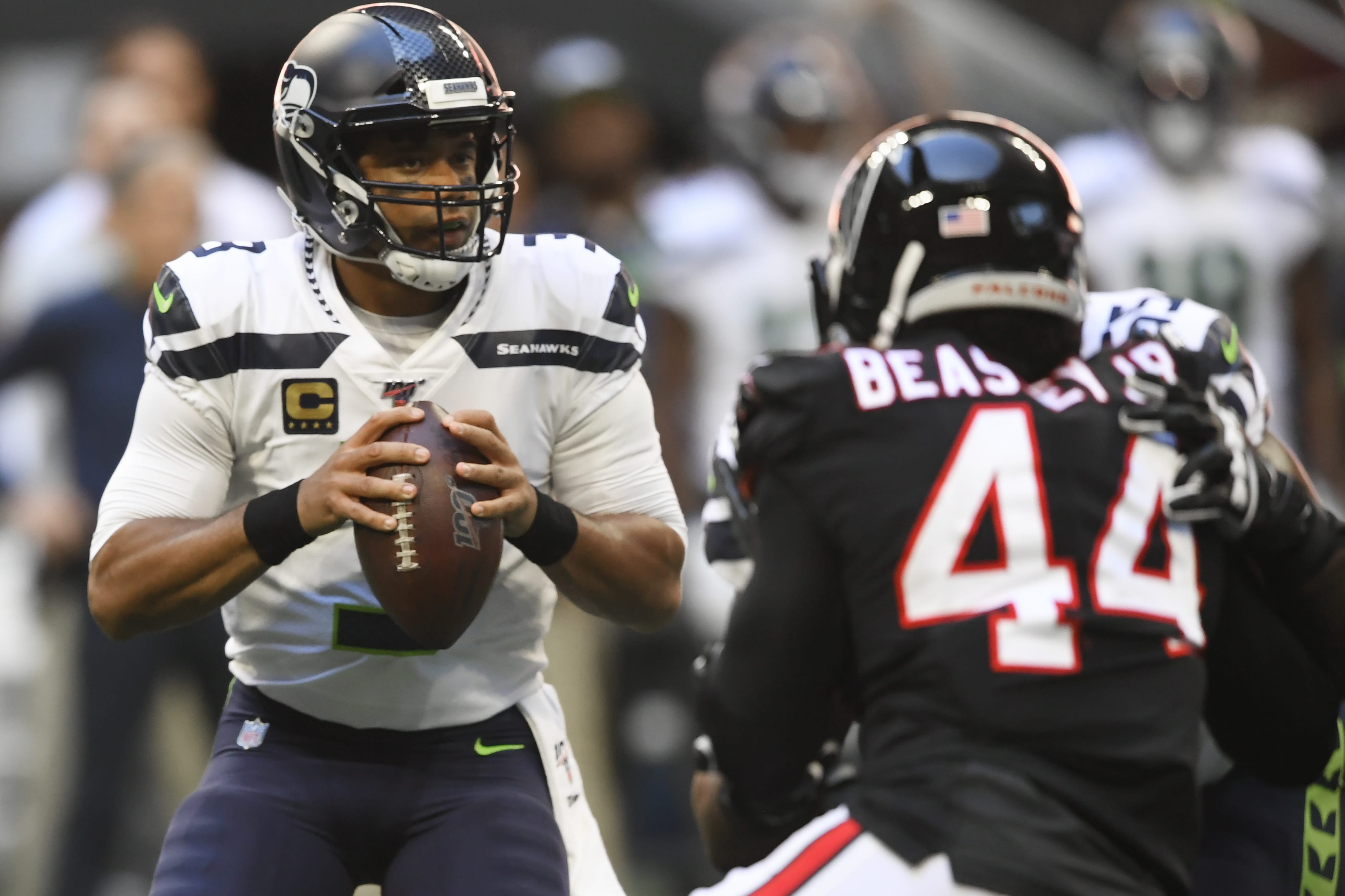 Seattle Seahawks quarterback Russell Wilson (3) works in the pocket as Atlanta Falcons defensive end Vic Beasley (44) pressures during the first half of an NFL football game, Sunday, Oct. 27, 2019, in Atlanta.