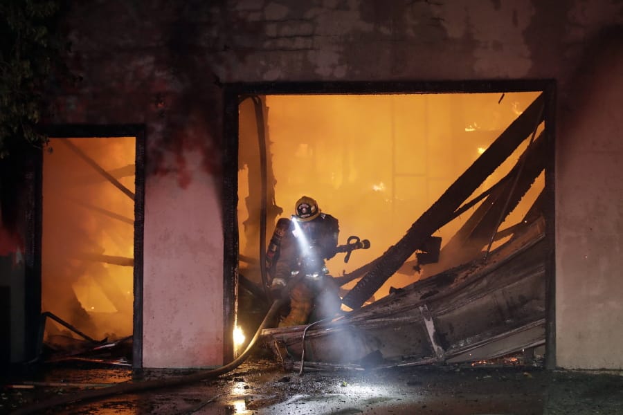 A firefighter works the scene of a wildfire-ravaged home Thursday, Oct. 24, 2019, in Santa Clarita, Calif. Fast-growing fires across California have forced thousands of people to evacuate as dry winds and high heat feed the flames.
