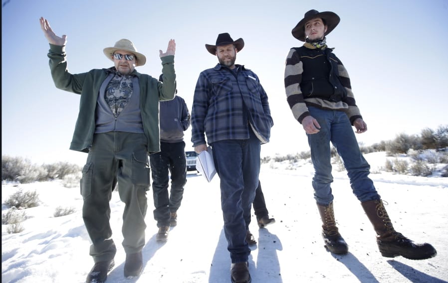 FILE - In this Jan 8, 2016, file photo, Burns resident Steve Atkins, left, talks with Ammon Bundy, center, one of the sons of Nevada rancher Cliven Bundy, following a news conference at Malheur National Wildlife Refuge near Burns, Ore. Bundy&#039;s family played central roles in a 2014 standoff over grazing fees in Nevada and the 2016 occupation of Oregon&#039;s Malheur National Wildlife Refuge.