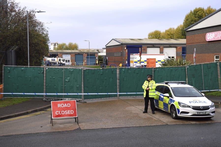 Police secure the area around the industrial estate where 39 lifeless bodies, eight women and 31 men, were discovered Wednesday in a truck, near Grays, southeast England, Friday Oct. 25, 2019.  China called Friday for joint efforts to counter human smuggling after the discovery in Britain of 39 dead people believed to be Chinese who stowed away in a shipping container.