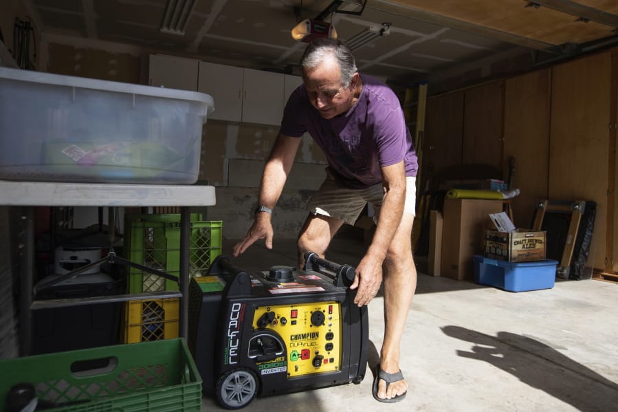 FILE - In this Tuesday, Oct. 8, 2019 file photo, Joe Wilson pulls his generator out in the garage of his home, which is in an area that is expected to lose power in the East Foothills area of San Jose, Calif. Power shutdowns intended to prevent more devastating California wildfires are raising concerns about another environmental threat: air pollution. As utilities temporarily halted service to more than 2 million people this week, many fired up standby generators that spew toxic emissions.