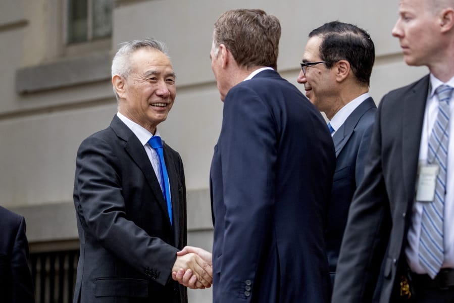 FILE - In this May 10, 2019, file photo, China&#039;s Vice Premier Liu He, left is greeted by U.S. Treasury Secretary Steve Mnuchin, second from right, and U.S. Trade Representative Robert Lighthizer, third right, as he arrives at the Office of the United States Trade Representative in Washington. China&#039;s Ministry of Commerce said Tuesday that Liu is going to Washington on Thursday for talks aimed at ending the tariff war.
