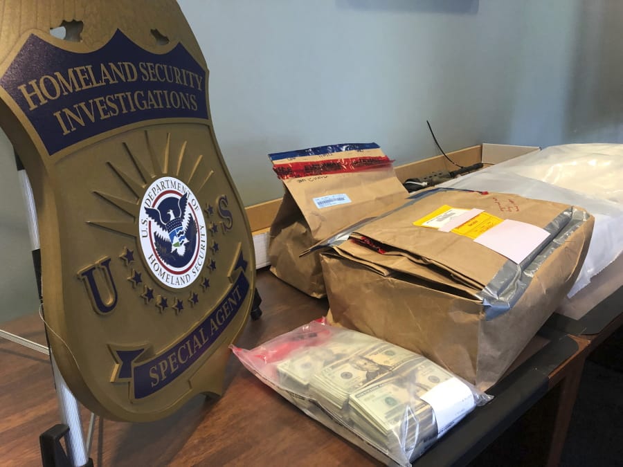 Evidence bags and money are displayed at a news conference, Wednesday, Oct. 2, 2019, in Portland, Ore. U.S. Attorney Billy Williams said that federal authorities in Oregon had completed one of the largest drug trafficking busts in state history that involved a vast international network of couriers, dealers and stash-house operators who smuggled methamphetamine, heroin and cocaine worth about $15 million from Mexico to Portland.
