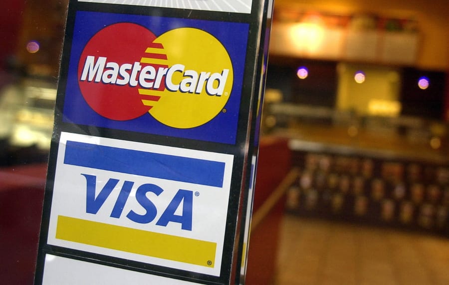FILE - This April 22, 2005, file photo, shows logos for MasterCard and Visa credit cards at the entrance of a New York coffee shop. Visa and Mastercard are dropping out of Facebook&#039;s Libra project, a potentially fatal blow to the social network&#039;s plan for a worldwide digital currency, Friday, Oct. 11, 2019.