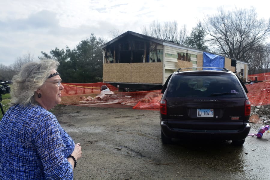 FILE - In this Sunday, April 7, 2019, file photo, Marie Chockley, a resident of the Timberline Trailer Court, north of Goodfield, Ill., surveys the damage that was caused by a Saturday night fire that killed five residents in a mobile home. A prosecutor says a central Illinois 9-year-old is expected to be charged Tuesday with five counts of first-degree murder in connection with the deadly mobile home fire.