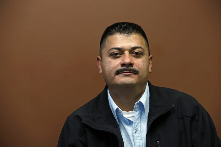 FILE - In this Oct. 17, 2014 file photo, Ignacio Lanuza sits for a portrait in Seattle. A federal judge on Tuesday, Oct. 29, 2019, criticized the Justice Department for seeking legal fees from Lanuza, a Mexican immigrant who was the victim of a forgery by a government lawyer.