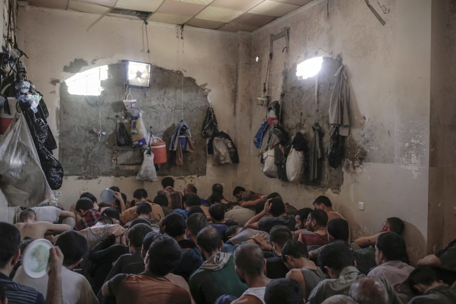 FILE - In this July 18, 2017 file photo, suspected Islamic State members sit inside a small room in a prison south of Mosul. The IS erupted from the chaos of Syria and Iraq&#039;s conflicts and swiftly did what no Islamic militant group had done before, conquering a giant stretch of territory and declaring itself a &quot;caliphate.&quot; U.S. officials said late Saturday, Oct. 26, 2019 that their shadowy leader Abu Bakr al-Baghdadi was the target of an American raid in Syria and may have died in an explosion.
