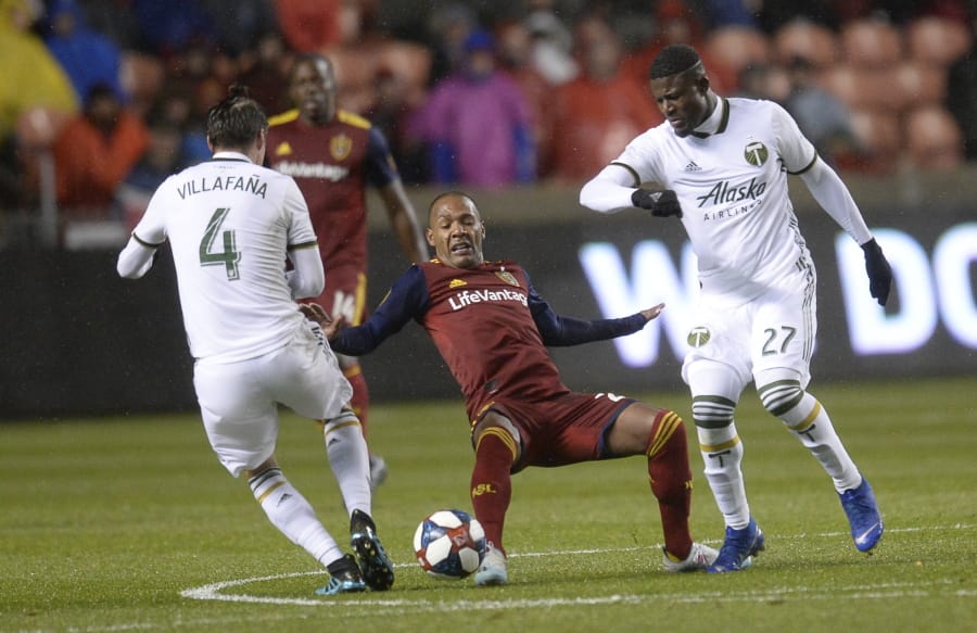 Portland Timbers defender Jorge Villafana (4) pressures Real Salt Lake midfielder Everton Luiz (25) with help from forward Dairon Asprilla (27) aduring the first half of an MLS soccer Western Conference first-round playoff match in Sandy, Utah, Saturday, Oct. 19, 2019.