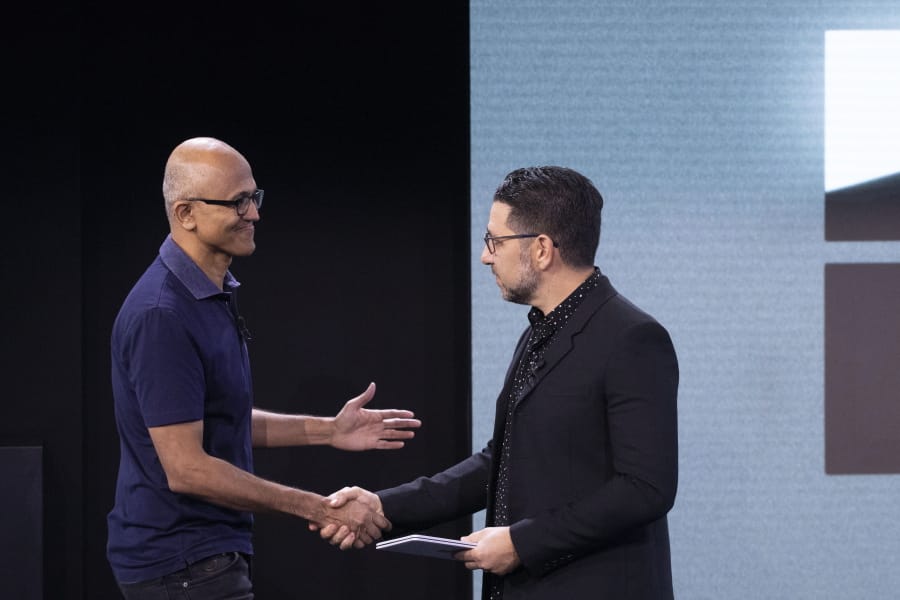 Microsoft CEO Satya Nadella, left, shakes hands with Chief Product Officer Panos Panay, who is holding a Surface Duo at an event Wednesday, Oct. 2, 2019, in New York.