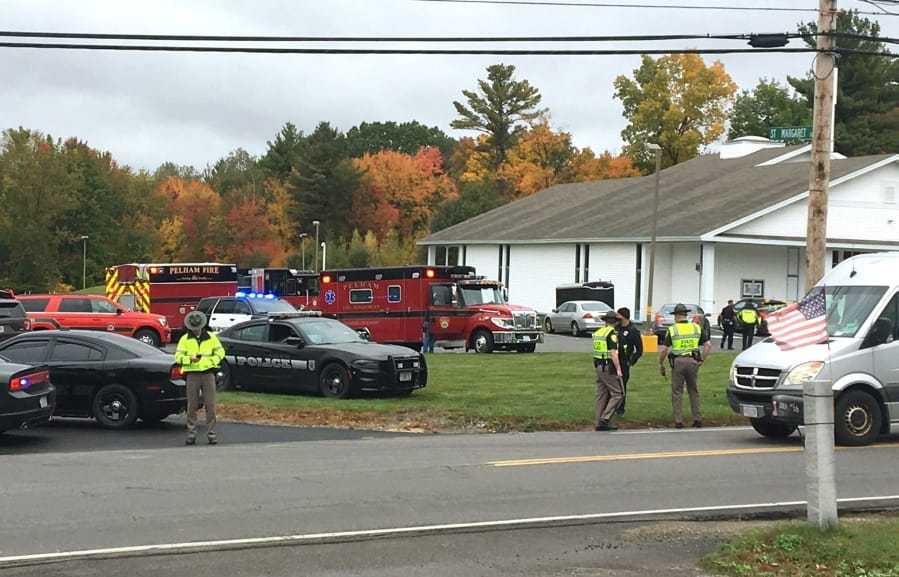 RETRANSMITTED WITH NEW SLUG AND BETTER QUALITY  - In this photo provided by WMUR-TV, police stand outside the New England Pentecostal Church after reports of a shooting on Saturday, Oct. 12, 2019, in Pelham, N.H. WMUR-TV reports that Hillsborough County Attorney Michael Conlon said a suspect is in custody.