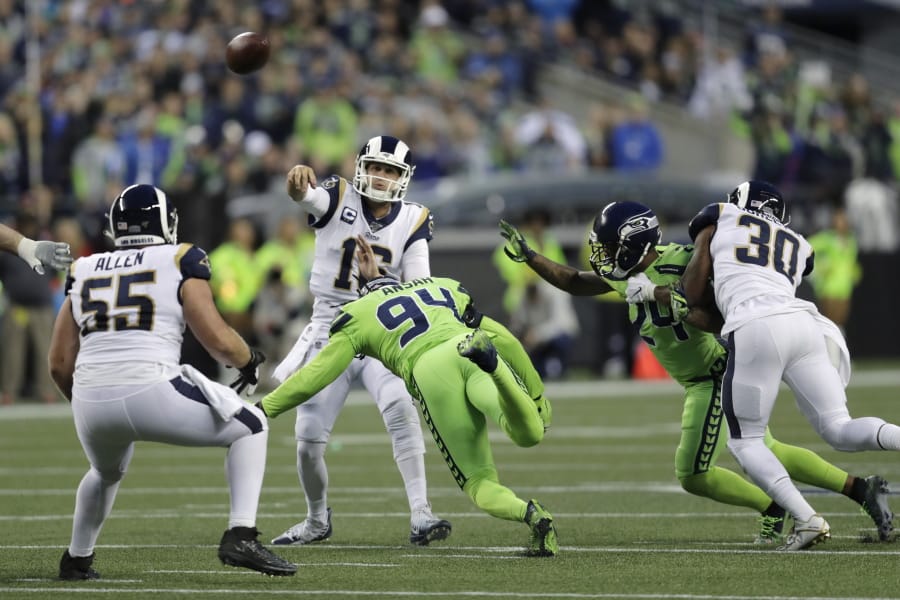 Los Angeles Rams quarterback Jared Goff, center, passes under pressure from Seattle Seahawks defensive end Ziggy Ansah (94) during the first half of an NFL football game Thursday, Oct. 3, 2019, in Seattle.