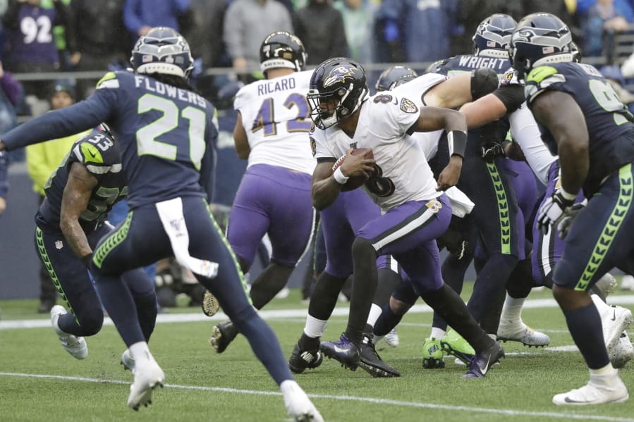 Baltimore Ravens quarterback Lamar Jackson (8) keeps the ball for a touchdown on a fourth-down play against the Seattle Seahawks during the second half of an NFL football game, Sunday, Oct. 20, 2019, in Seattle.
