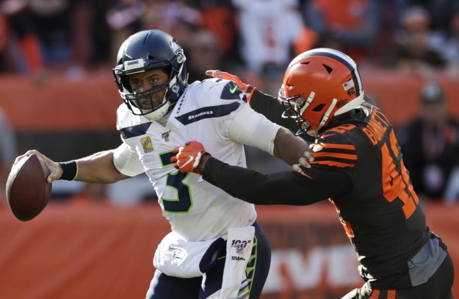 Seattle Seahawks quarterback Russell Wilson (3) avoids Cleveland Browns strong safety Morgan Burnett (42) during the second half of an NFL football game, Sunday, Oct. 13, 2019, in Cleveland.