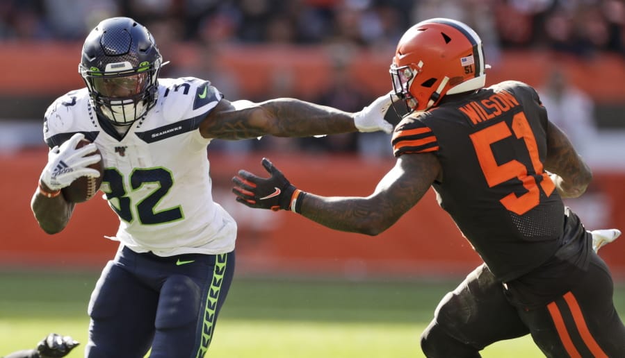 Seattle Seahawks running back Chris Carson (32) rushes against Cleveland Browns linebacker Mack Wilson (51) during the second half of an NFL football game, Sunday, Oct. 13, 2019, in Cleveland.