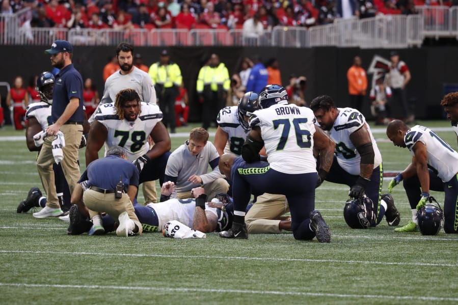 Seattle Seahawks center Justin Britt (68) lies injured against the Atlanta Falcons during the first half of an NFL football game, Sunday, Oct. 27, 2019, in Atlanta.