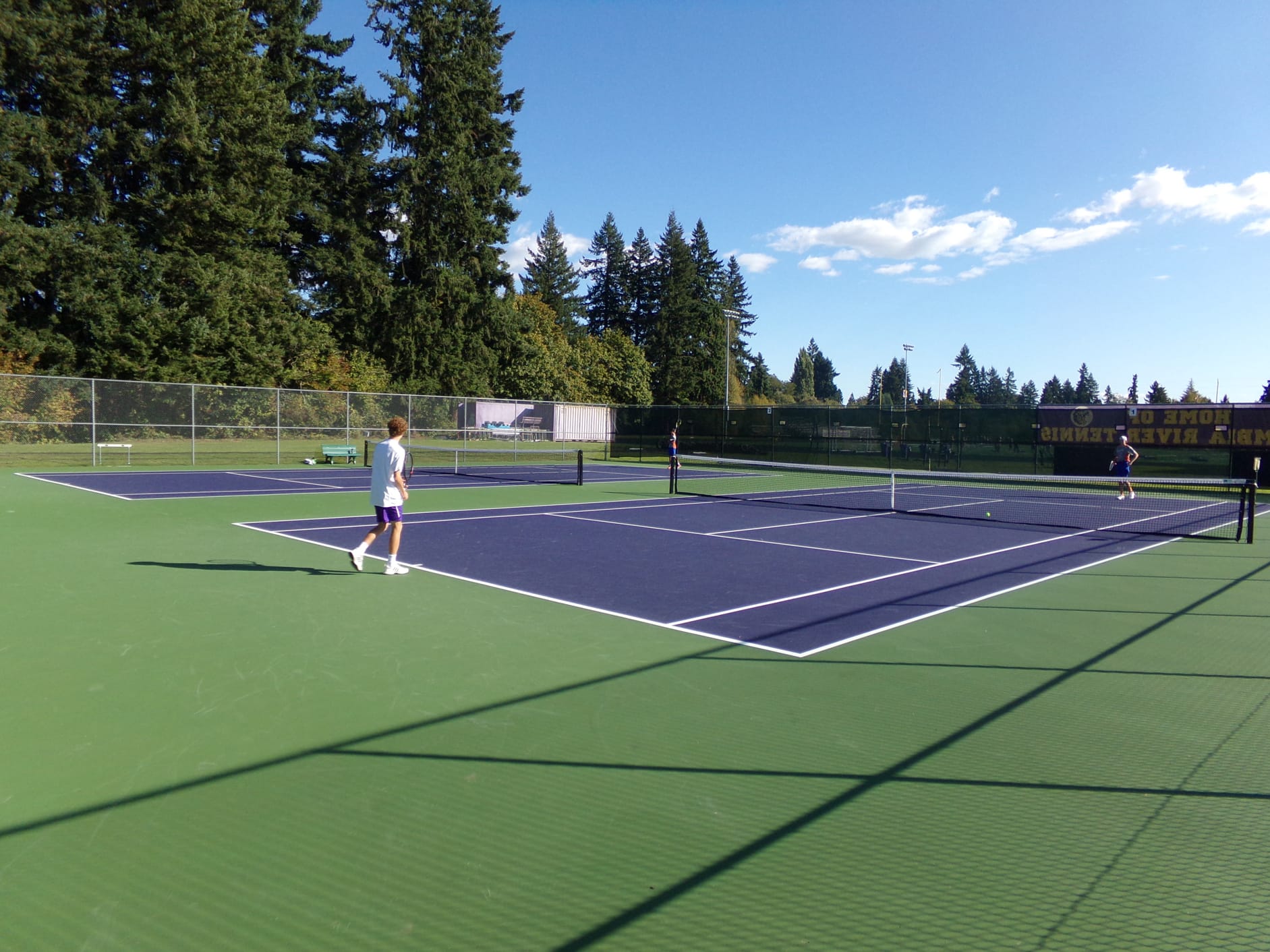 Columbia River's Wilson Keller takes on Ridgefield's Derek Kropp on the newly surfaced courts at Columbia River High School (Tim Martinez/The Columbian)