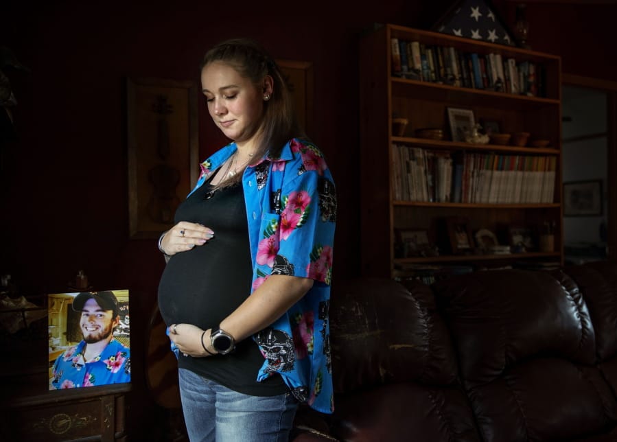 Krista Johnston stands next to a photo of her husband, Sgt. James Johnston, who was killed in Afghanistan in June, while pregnant with their first child, in Trumansburg, N.Y., Saturday, Aug. 31, 2019. As the nation&#039;s longest war marks the end of its 18th year, Krista returned to her tiny hometown for two milestones: In one weekend in the local American Legion hall, she joined hundreds to pay tribute to her husband with a 21-gun salute, TAPS and remembrances. A day later, she returned for a baby shower, celebrating the impending birth of their daughter he didn&#039;t live to see.