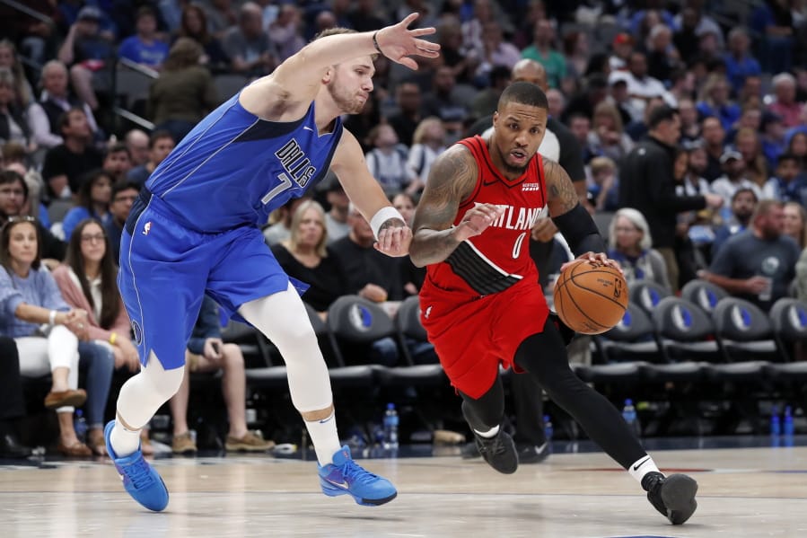 Dallas Mavericks guard Luka Doncic, left, defends agains a drive to the basket by Portland Trail Blazers&#039; Damian Lillard (0) in the second half of an NBA basketball game in Dallas, Sunday, Oct. 27, 2019.