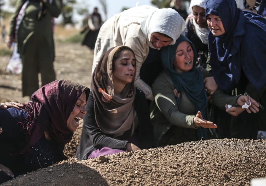 Relatives of Halil Yagmur, 64, who was killed Friday during mortar shelling from Syria, mourn over his grave at the cemetery in the town of Suruc, southeastern Turkey, at the border with Syria, Saturday, Oct. 12, 2019. Turkish forces entered Saturday the center of the Syrian border town of Ras Al-Ayn under heavy bombardment, the Turkish military and a Syrian war monitor said, as Turkey&#039;s offensive against Syrian Kurdish fighters pressed into its fourth day with little sign of relenting despite mounting international criticism.