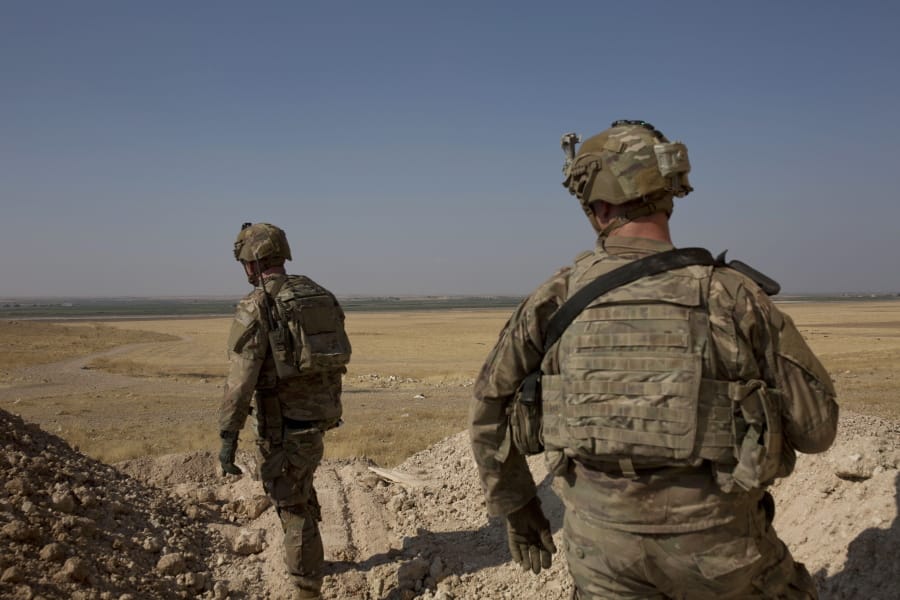 FILE - In this Sept. 6, 2019 file photo, U.S. soldiers survey the the safe zone between Syria and the Turkish border near Tal Abyad, Syria, on a joint patrol with the Tax Abyad Military Council, affiliated with the U.S.-backed Syrian Democratic Forces. Defense Secretary Mark Esper says that under the current plan all U.S. troops leaving Syria will go to western Iraq, and that the military will continue to conduct operations against the Islamic State group to prevent a resurgence in that country.