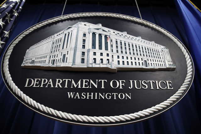 In this Thursday, April 18, 2019, file photo, a sign for the Department of Justice hangs in the press briefing room at the Justice Department, in Washington.