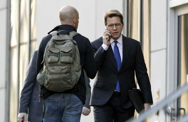 Mark Lanier, right, an attorney for the plaintiffs, enters the U.S. Federal courthouse, Monday, Oct. 21, 2019, in Cleveland. The nation's three dominant drug distributors and a big drugmaker have reached a tentative deal to settle a lawsuit related to the opioid crisis just as the first federal trial over the crisis was due to begin Monday, according to a lead lawyer for the local governments suing the drug industry.