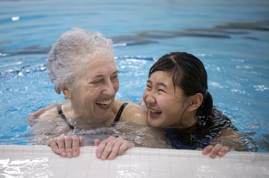Mollie Hands and Li Ling Joosten, 12, play together in the water during an open swim session. &quot;She comes in once a week to just visit with the students and be a friend,&quot; said Adrienne Fernandez, volunteer coordinator at the Washington State School for the Blind.