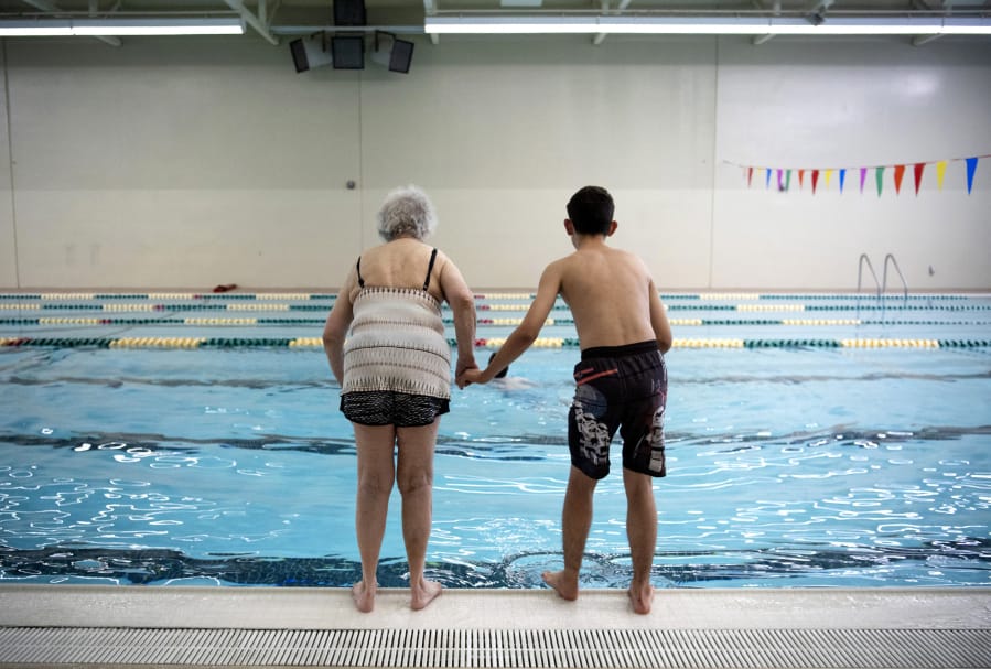 Mollie Hands, left, and Gabe Pizzo, 14, stand poised to jump into the pool on the count of three at the Washington State School for the Blind. While Hands made the plunge, Gabe remained at the edge of the pool giggling at his trick. When Hands broke the surface laughing, Gabe jumped in to join her.