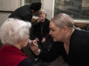 Certified makeup artists Monique Contreras, back left, and Cedar Lapp, right, apply makeup to Lucy Campbell, far left, and Beverly Wagner, center, at Vancouver Orchards Retirement Community in Vancouver. In recognition of Alzheimer&#039;s awareness month, activities coordinator Tracy Shanks organized a makeover with Cedar&#039;s Academy of Makeup Artistry, and a photo session for the residents.