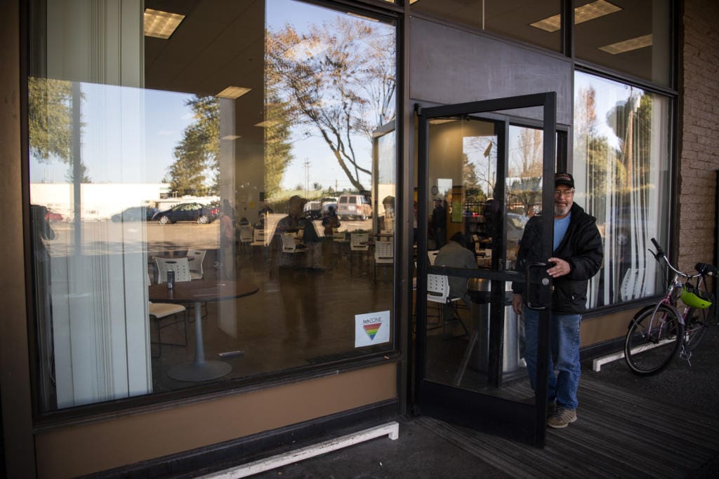 Scott Gibson chats with a friend outside of the Vancouver Navigation Center in Vancouver on Nov. 1. All entry into the building might soon be moved to this door instead of the side door under the awning. Gibson is currently living in a van and waiting for housing options.