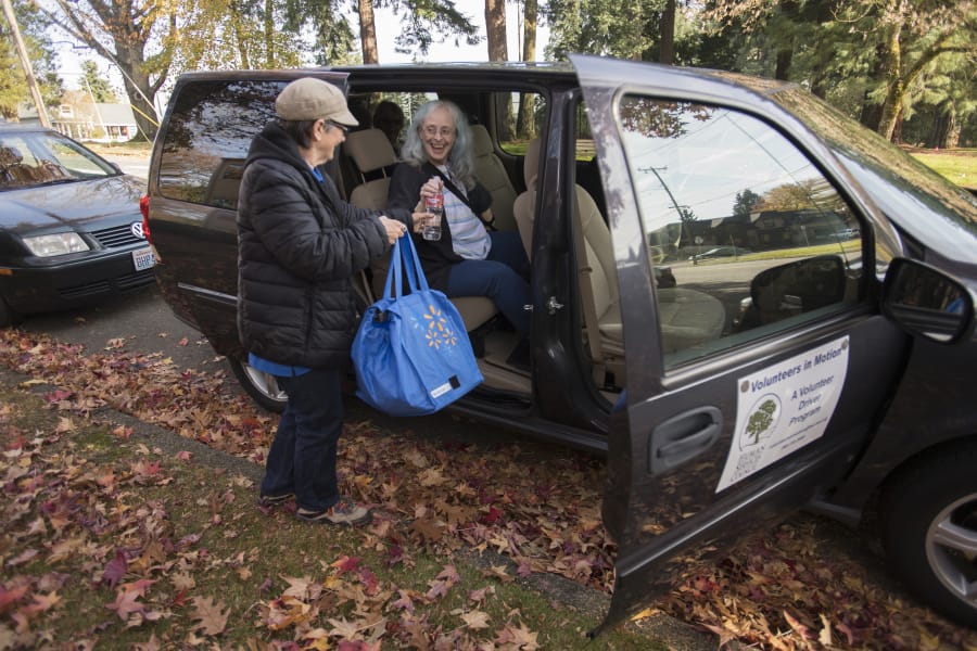 Volunteer driver Joanne Pritchard, left, hands a shopping bag to Crown Villa Apartments resident Linda Crooks as they prepare for a trip to Walmart on Friday afternoon. The ride was free through the Human Services Council&#039;s new Volunteers in Motion program.