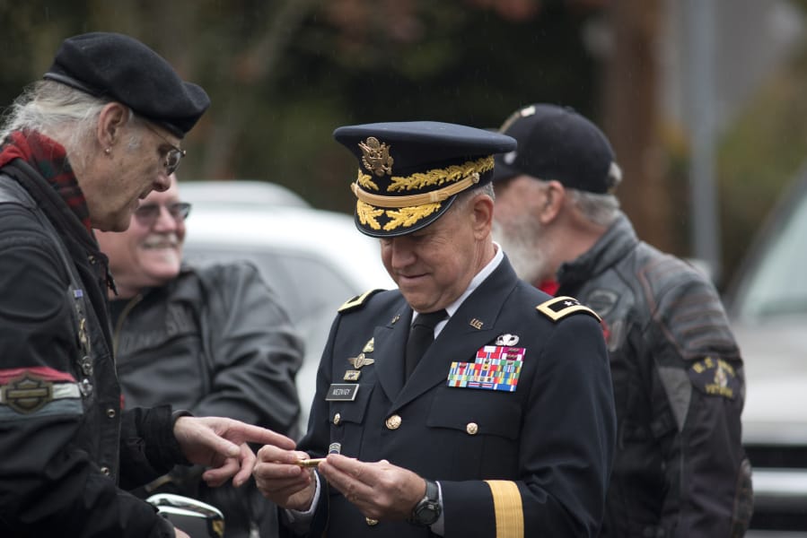 Clark County Councilor Gary Medvigy accepts a commemorative pen from Patriot Guard Rider Greg Whitson of Vancouver during the 33rd annual Lough Legacy Veterans Parade at the Fort Vancouver National Site.