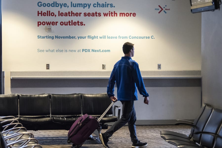 A commuter walks past a sign advertising the closure of Concourse A at Portland International Airport on Wednesday morning, the concourse&#039;s last day of operation.
