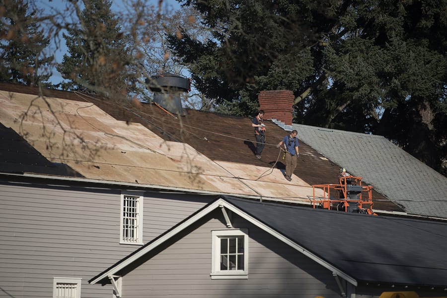 Construction crews help install a new roof at the Quartermaster Storehouse while preserving the original historic fabric at Fort Vancouver National Site on Nov. 21. The old storehouse was one of 16 historic buildings at the site to receive a new roof.