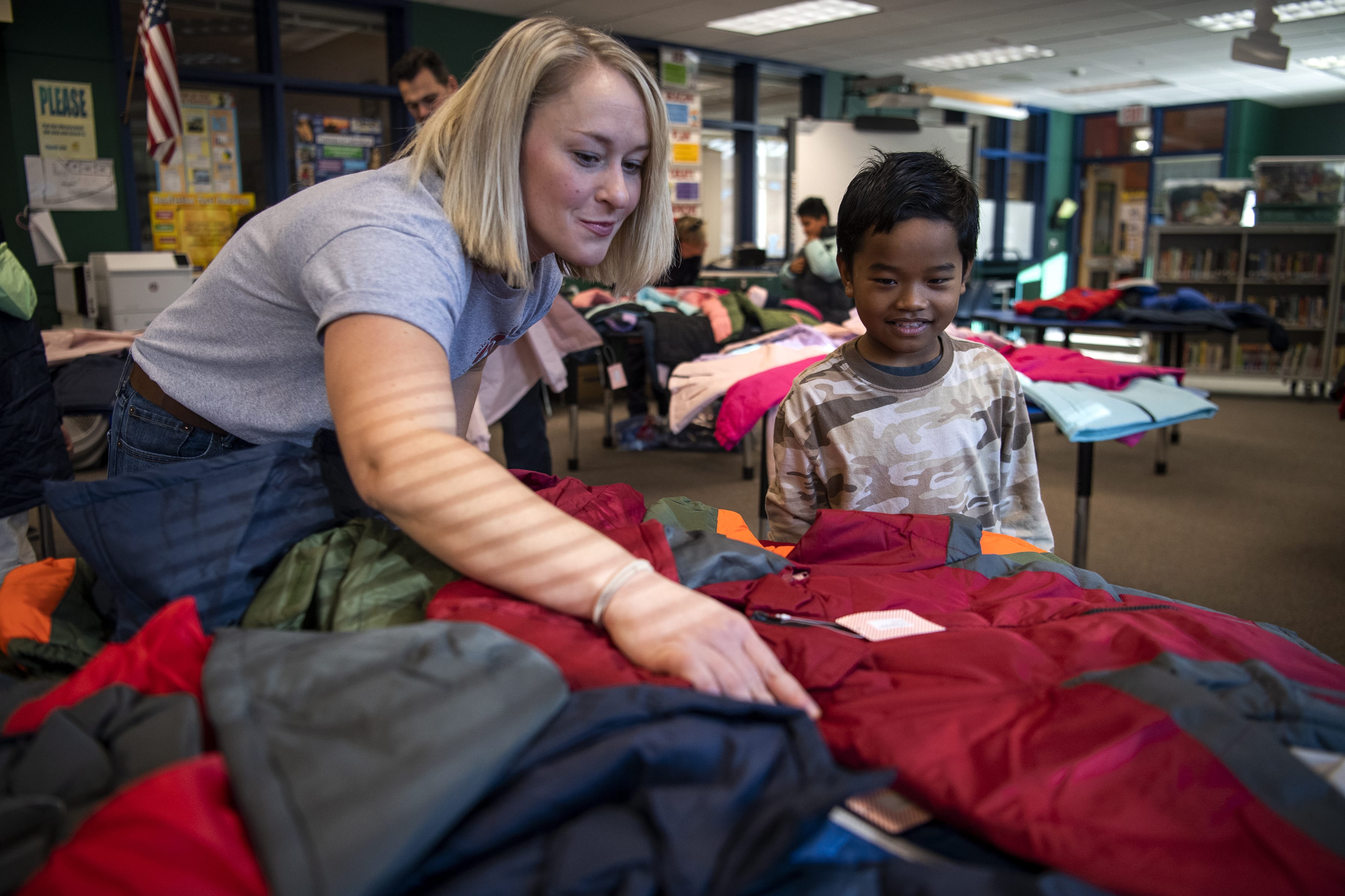 Vancouver Fire Department firefighter Kady Bieber, left, helps second-grader Erson Ermay pick out a new winter coat Thursday at Washington Elementary School in Vancouver. Firefighters with IAFF have partnered with Operation Warm to distribute more than 200,000 coats in more than 300 cities nationwide since 2012. Dutch Bros Coffee and Paul Davis Restoration partnered with Local 452 to help raise funds for this year's event.