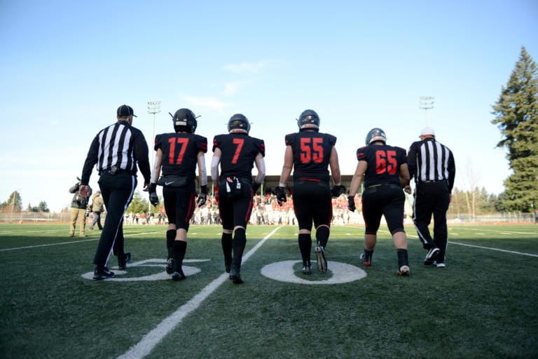 Camas football players Kolby Broadbent, left, Tyler Forner, Tristan Souza, and Tai Tumanuvao approach the coin toss before a game against Mount Si at McKenzie Stadium on Saturday afternoon, November 30, 2019. Camas beat Mount Si 35-14 to move on to the 4A state title game.