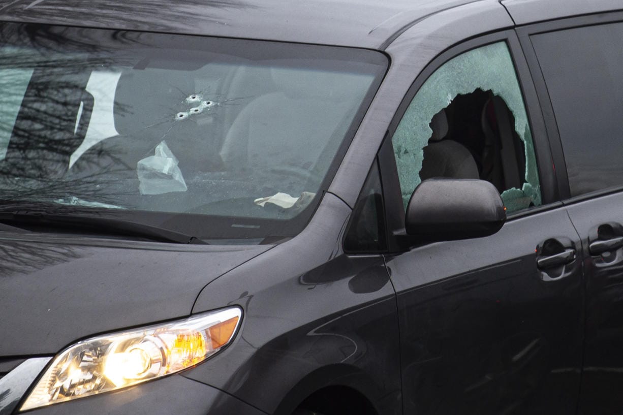 Bullet holes and a smashed window can be seen on the Toyota Sienna van where the shooting took place Tuesday.