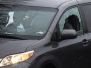 Bullet holes and a smashed window can be seen on the Toyota Sienna van where the shooting took place Tuesday.