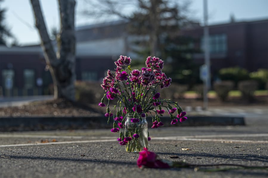 Flowers are seen Friday, Nov. 29, in the parking spot where two people were shot Nov. 26 in a domestic violence homicide and attempted homicide at Sarah J. Anderson Elementary School.