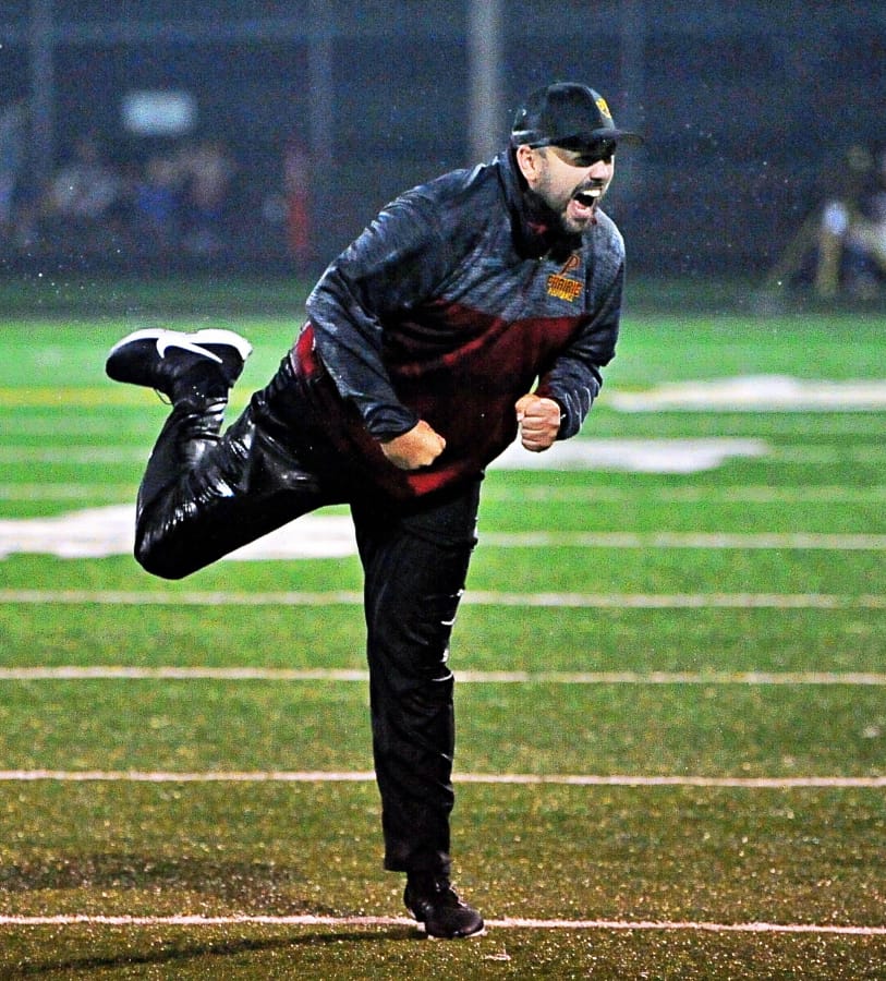 Prairie coach Mike Peck pumps his fist and lets out a roar after his team dumped a bucket of water on him late in the Falcons' 42-14 win over Evergreen on Friday at District Stadium in Battle Ground. The win secures Prairie's first league title since 1992.