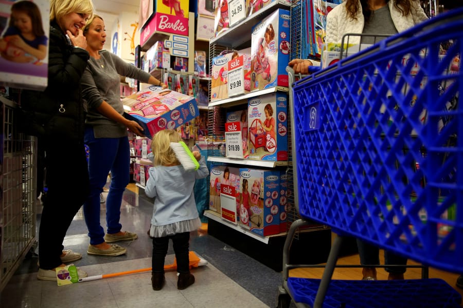 Joanne Wright, from left, and her daughter-in-law Alison Wright navigate the sale aisles at Toys R Us in Chicago with Alison&#039;s twin daughters, 23 months old, in tow. (Liz O.