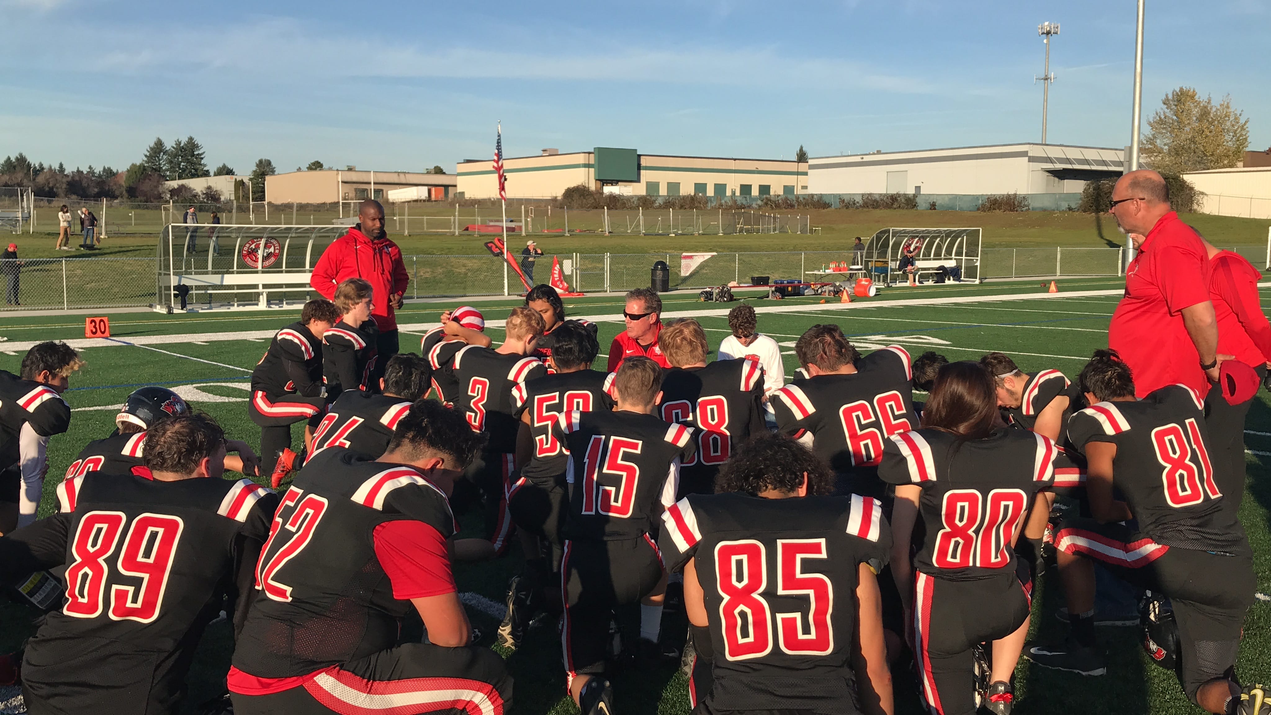 Fort Vancouver players listen to head coach Neil Lomax postgame after Saturday’s 42-7 los to West Seattle. The Trappers went 1-8 in their first season as an independent.