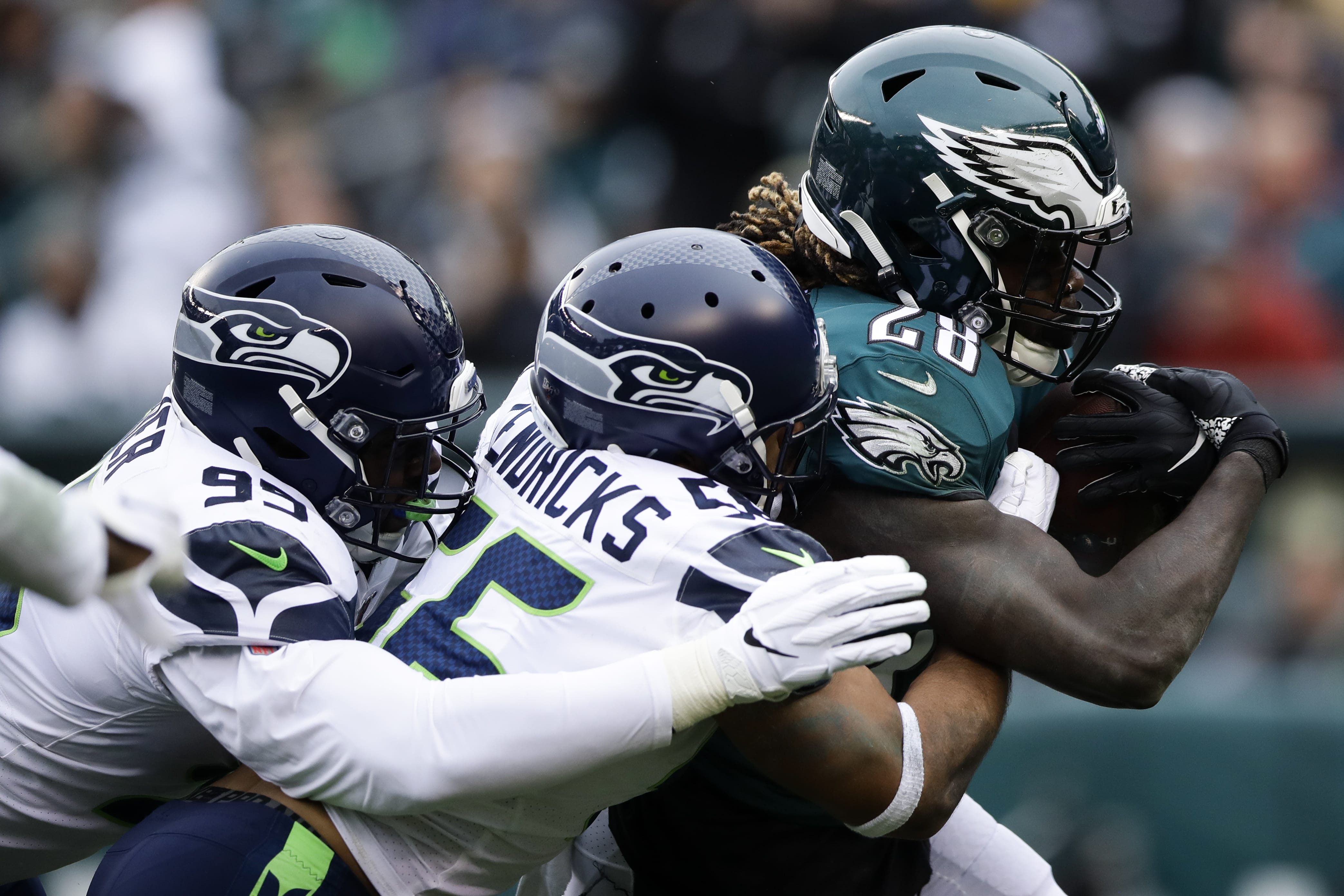 Philadelphia Eagles' Jay Ajayi (28) is tackled by Seattle Seahawks' Mychal Kendricks (56) and L.J. Collier (95) during the first half of an NFL football game, Sunday, Nov. 24, 2019, in Philadelphia.