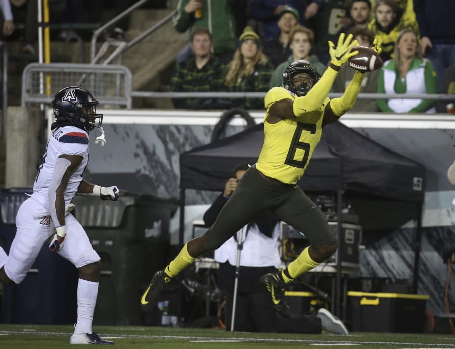 Oregon&#039;s Juwan Johnson, right, pulls down a Justin Herbert pass on his way to a touchdown ahead of Arizona&#039;s Christian Roland-Wallace, left, during the second quarter of an NCAA college football game Saturday, Nov. 16, 2019, in Eugene, Ore.